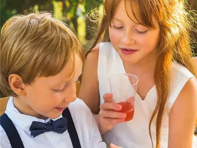 Junge mit Fliege und Mädchen im Festkleid auf einer Hochzeit